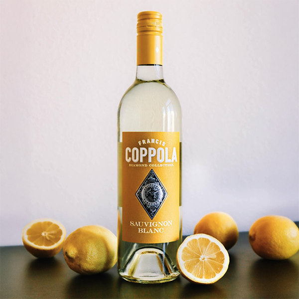 Botella de Francis Coppola Diamond Sauvignon Blanc rodeada de limones.